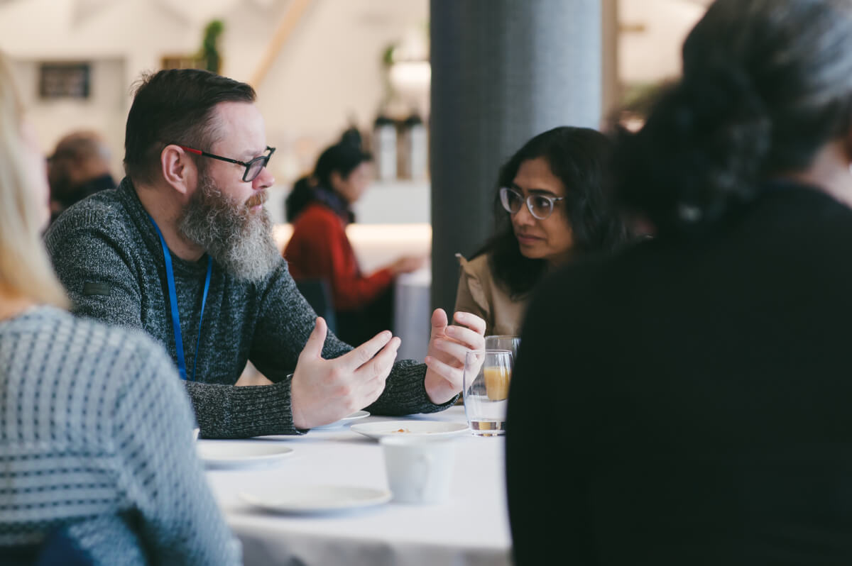A group sat at a table having a discussion during one a Wavelength session